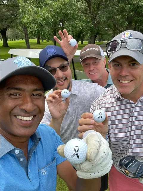 Golfers holding up their golf balls