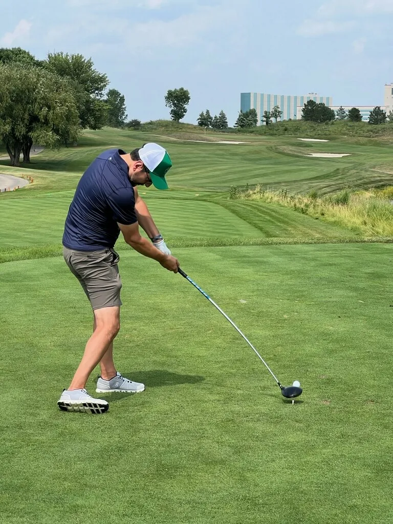 A golfer mid-swing off the tee