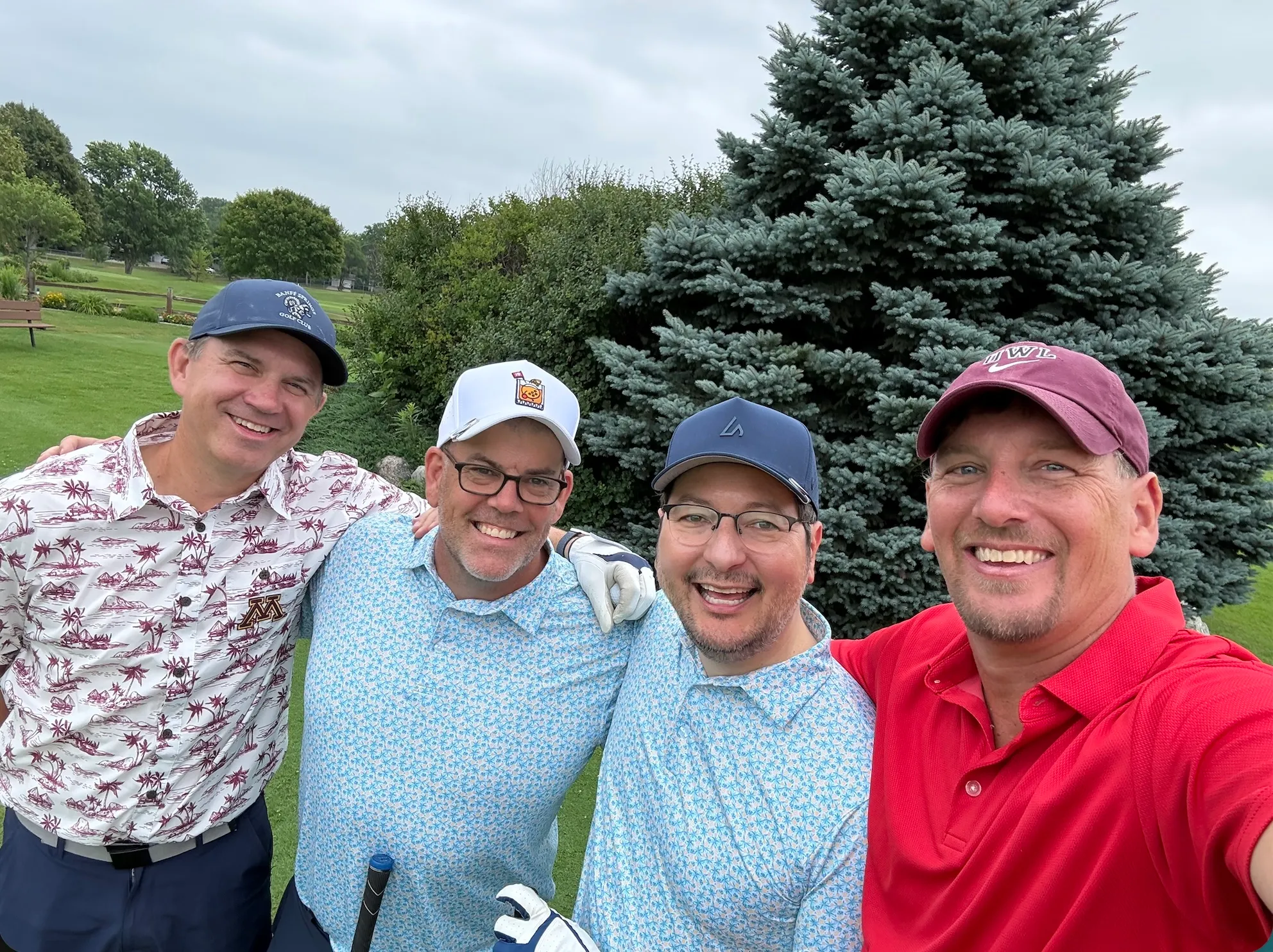 Four golfers posing together on the course