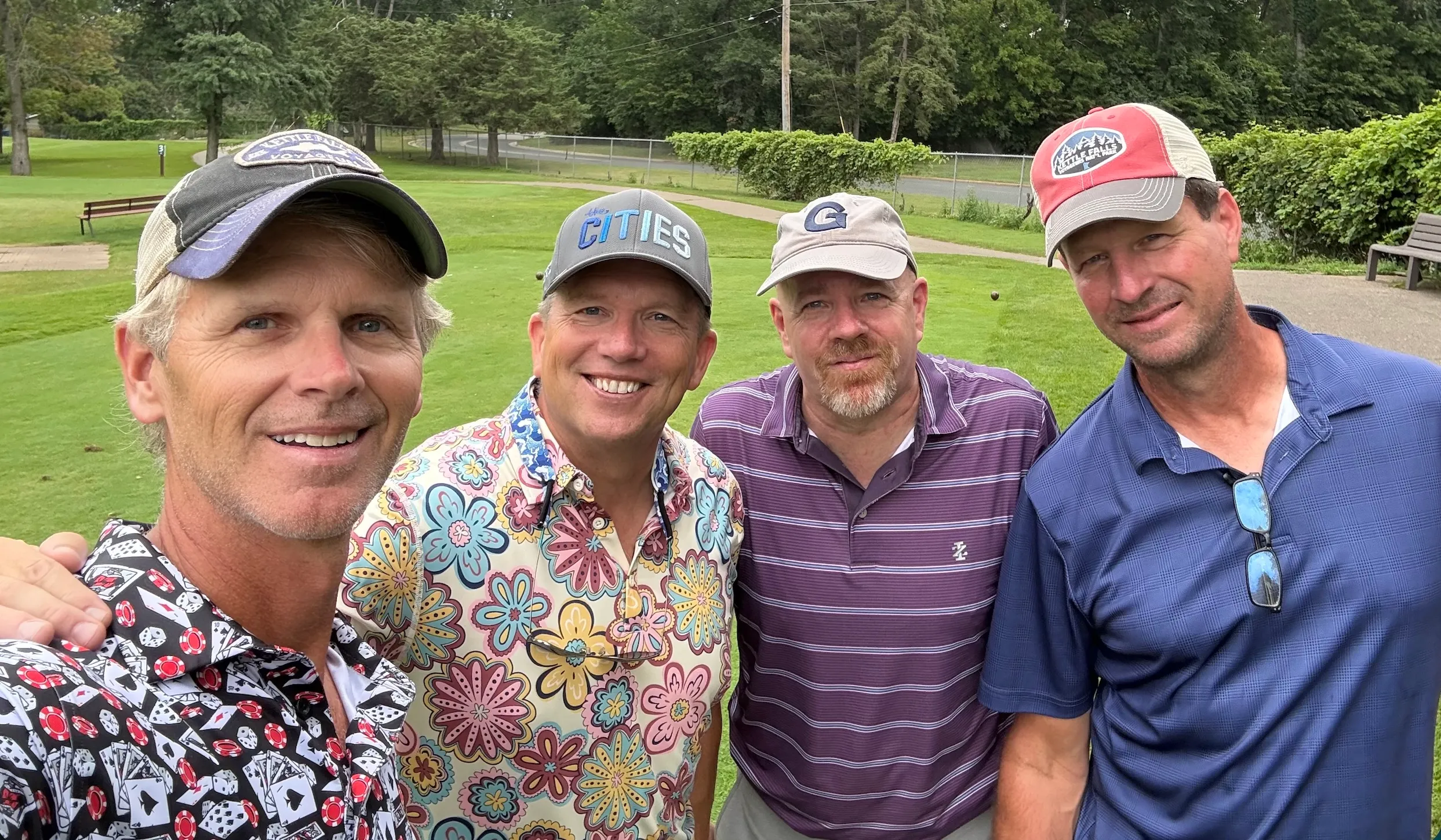 A foursome smiling for a photo on the course