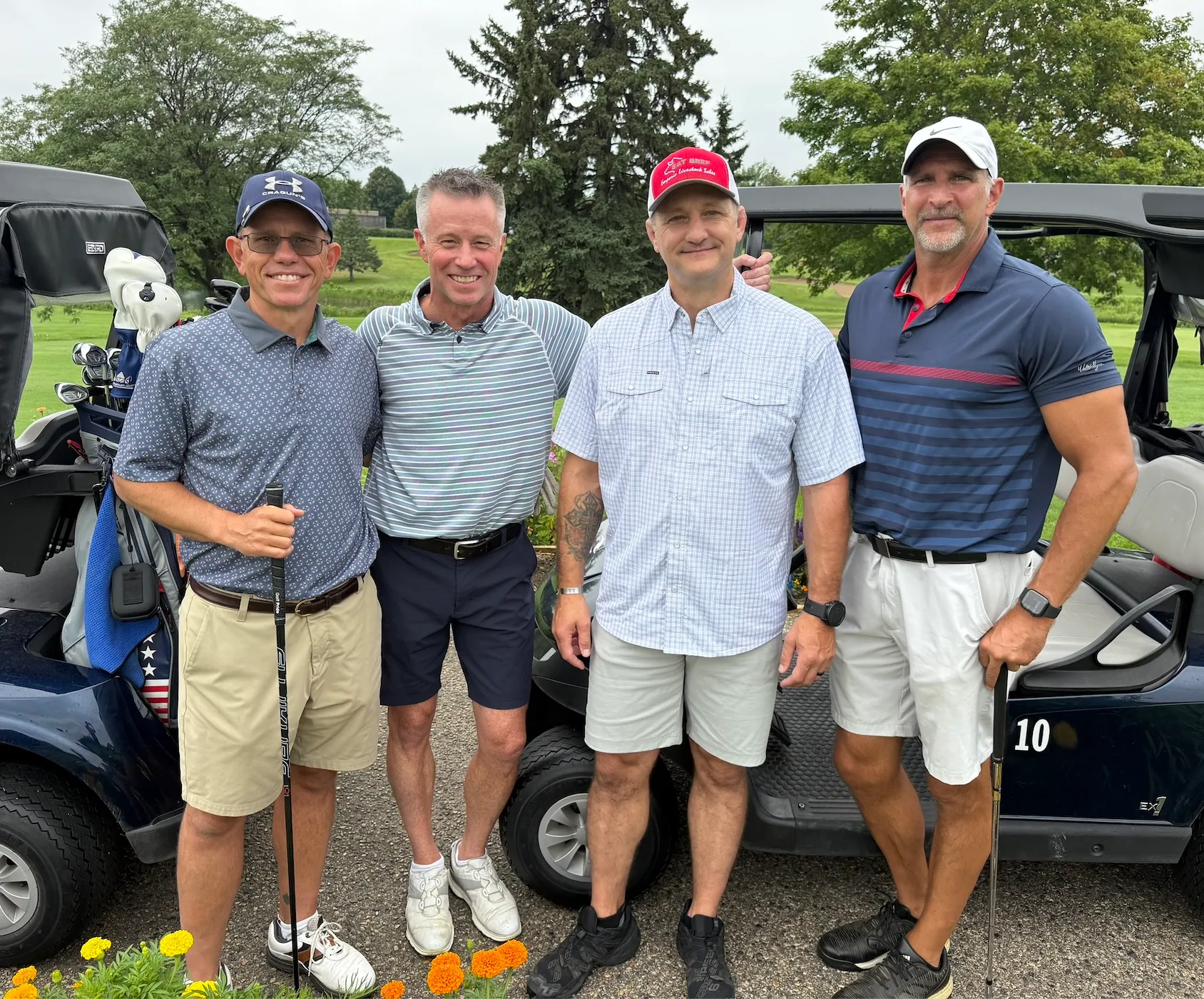 A foursome posing by their cart